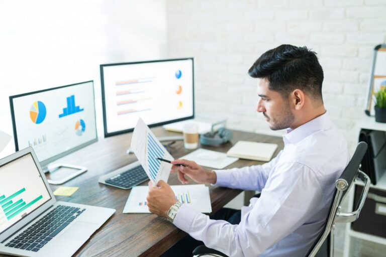 Statistician analysing clinical data on dual monitors