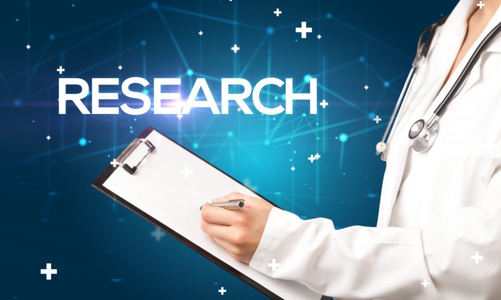 Doctor fills out medical record with RESEARCH inscription, medical concept